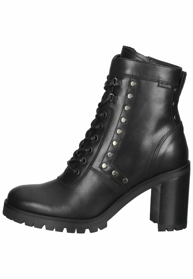 Bottine en cuir noir avec un talon haut épais, un avant à lacets et des clous métalliques sur le côté. Semelle robuste pour une bonne adhérence.