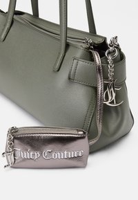 Grøn tekstureret tote taske med to håndtag, der har en sølv kæde og en metallisk pink pung prægede med "Juicy Couture."