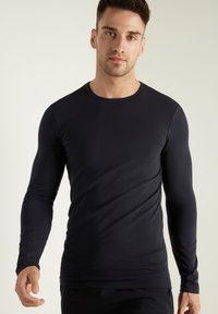Schwarzes Langarmshirt aus glattem Stoff, mit Rundhalsausschnitt und taillierter Silhouette. Keine sichtbaren Muster oder Verzierungen.