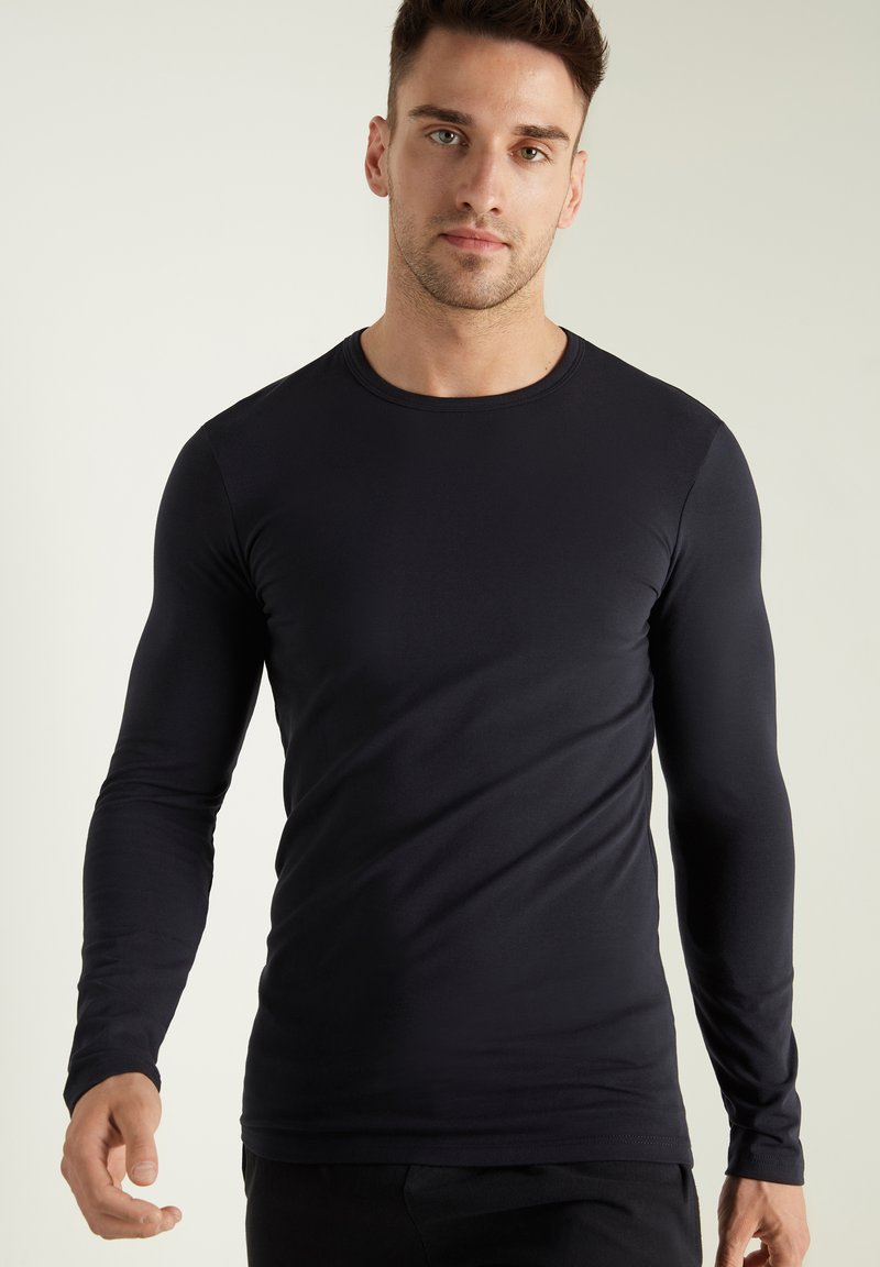 Schwarzes Langarmshirt aus glattem Stoff, mit Rundhalsausschnitt und taillierter Silhouette. Keine sichtbaren Muster oder Verzierungen.