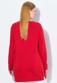 Maglione rosso a maniche lunghe con una vestibilità rilassata, caratterizzato da spacchi laterali, texture a maglia e orlo dritto.