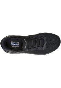 Zapatos negros tipo slip-on de Skechers con parte superior de tejido de malla, cordones elásticos, cuello acolchado y suela de goma texturizada para mayor agarre.