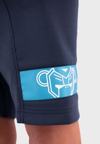 Marineblauwe sportshorts met een turquoise paneel met patroon en een wit grafisch ontwerp. Het materiaal is glad en lichtgewicht, geschikt voor actieve doeleinden.