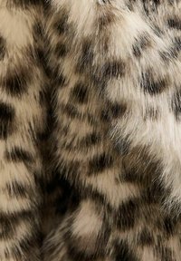 Luipaardprint nepbontmateriaal, met een zachte, pluizige textuur en zwarte vlekken op een beige achtergrond.