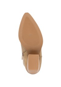 Zapato de tacón alto beige con punta afilada y suela de goma texturizada. Detalle de cremallera lateral y una base de tacón cuadrada para mayor estabilidad.
