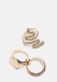 Guld-farvede ringe: en snoet slangedesign med glitrende accenter, den anden en simpel ring med en glat, poleret overflade.