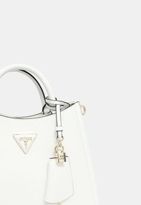 Borsa bianca strutturata con una forma definita, caratterizzata da un logo triangolare, dettagli neri e un charm decorativo a forma di lucchetto.