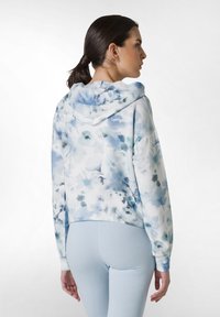 Blomtryckt hoodie i ljusblå och vit, med huva, långa ärmar och en kortad design. Mjuk textur med en avslappnad passform.