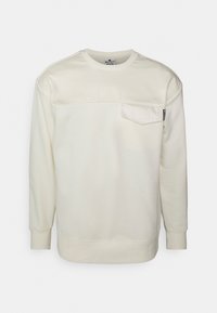 Felpa color crema con maniche lunghe, scollo arrotondato, tasca frontale e polsini a costine. Realizzata in tessuto morbido con una texture liscia.