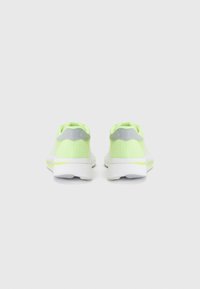 Scarpe da ginnastica con tomaia in rete traspirante di colore giallo neon e bianco, dotate di un tallone grigio a contrasto e di una suola bianca rinforzata.