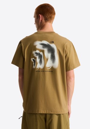 Olivengrøn bomulds-T-shirt med et grafisk design på ryggen med sorte og hvide penselstrøg og tekst: "STOP ALDRIG MED AT UDFORSKE."