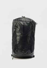 Μαύρο σακίδιο πλάτης από ανθεκτικό υλικό, με κομψό σχεδιασμό, υφή στην επιφάνεια, ρυθμιζόμενους ιμάντες και μπροστινό ελαστικό κορδόνι για επιπλέον αποθηκευτικό χώρο.