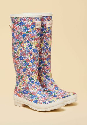 Paar põlveni ulatuvaid vihmavarujaid mitmevärvilise lillemustriga ja valgete talladega, millel on ülaosas "Joules" logo.