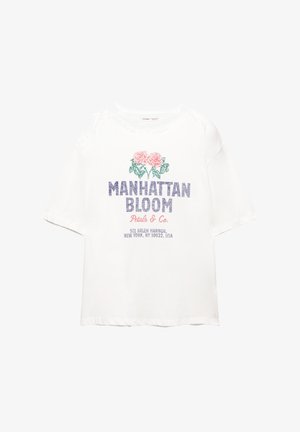 Vit bomull t-shirt med ett motiv av rosa rosor och "MANHATTAN BLOOM" i blått, med ytterligare text i mindre teckenstorlek nedan.