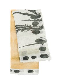 Lekki szalik w kolorze kremowym i delikatnym pomarańczowym, zdobiony czarnymi roślinnymi wzorami oraz kropkami, z postrzępionymi brzegami.