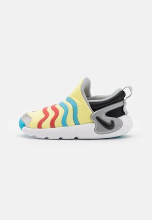 Gul slip-on sneaker med røde og blå bølgemønstre, gråt polstret krave, sort hældetalje og hvid tyk sål.