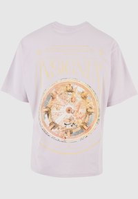 Lilla bomulls t-skjorte med et stort, detaljerte rundt grafikk med utsmykkede design og ordet "INSIGNIA" i fet gul tekst.