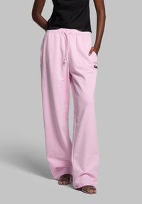 Bløde, lyserøde sweatpants med vidde og elastisk talje samt funktionelle lommer. Enkelt design med et lille logo på siden.