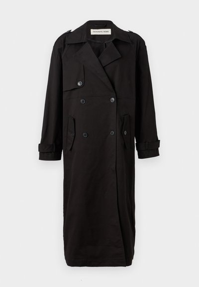 Manteau noir en tissu lisse, avec un devant croisé, des épaulettes, et des poches latérales avec des poignets retroussés.
