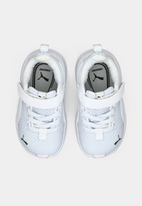 Weiße Mesh-Sneaker mit einer strukturierten Oberfläche, ausgestattet mit einem weißen Riemen und Schnürsenkeln, schwarzen Logo-Highlights und einem gepolsterten Innenraum für Komfort.