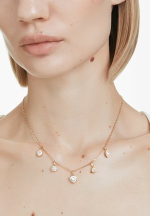 Collana in oro con cinque cristalli a forma di cuore pendenti di diverse dimensioni, che aggiungono texture e brillantezza al design.