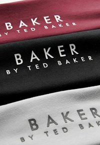 Tričko látky v marhuľovej, čiernej a sivej farbe, pričom každé z nich zobrazuje text "BAKER BY TED BAKER" písmom tučne v bielej farbe.