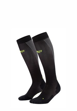 Schwarze knielange Socken mit strukturiertem Rippdesign, limonengrünen Akzenten und einer eng anliegenden Passform zur Unterstützung. Verfügt über verstärkte Zehen- und Fersenbereiche.