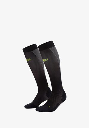 Schwarze knielange Socken mit strukturiertem Rippdesign, limonengrünen Akzenten und einer eng anliegenden Passform zur Unterstützung. Verfügt über verstärkte Zehen- und Fersenbereiche.