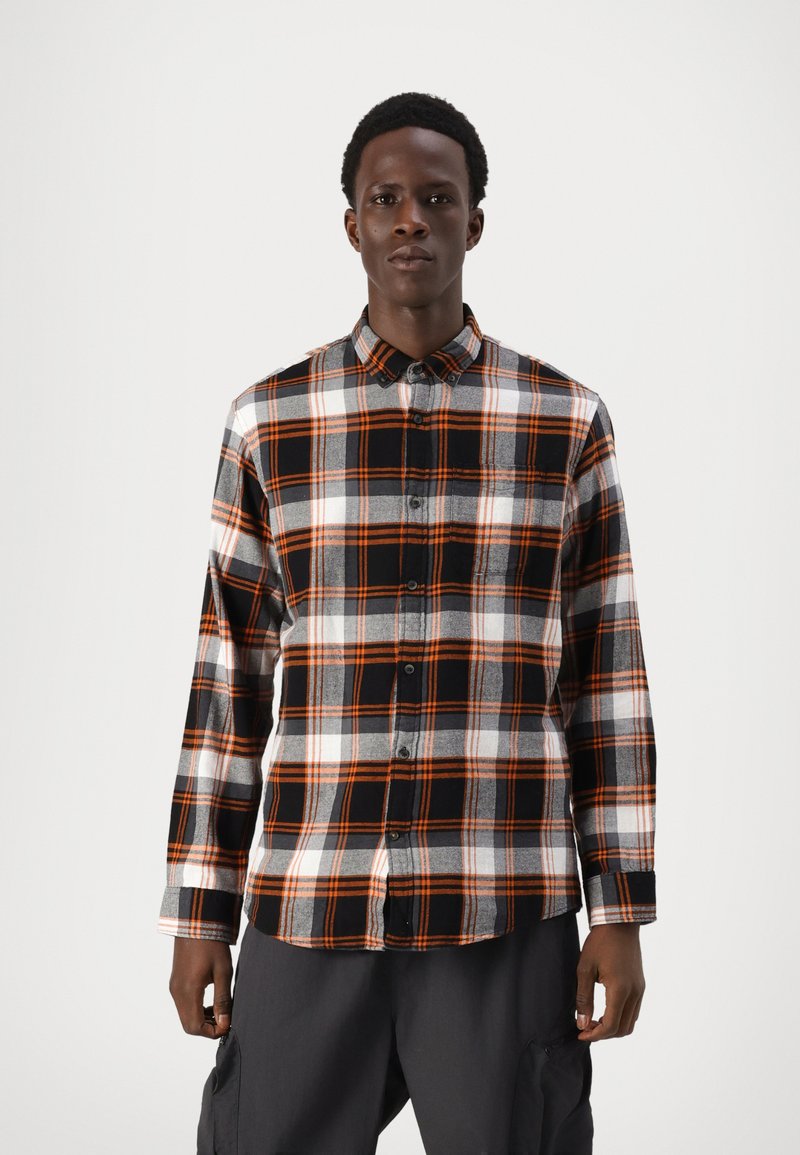 Zwart en oranje geruite blouse met lange mouwen, knoopsluiting aan de voorkant, witte en grijze accenten en een gebogen zoom. Geweven stof.