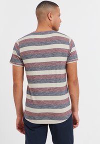 Striped t-shirt featuring horizontal bands in red, blue, and cream. Made from soft fabric with a relaxed fit and crew neckline.