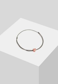 Hallhalli reguleeritav käevõru, mis on valmistatud nöörist ja millel on sile roosa südame ripats. Käevõru on lihtsa disainiga ja minimaalsete kasutatud metalldetailidega.