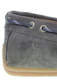 Grå mocka slip-on sko med en texturerad yta, rund tå och ögla i guldton för snörning. Den mjuka gummisulan är något genomskinlig.