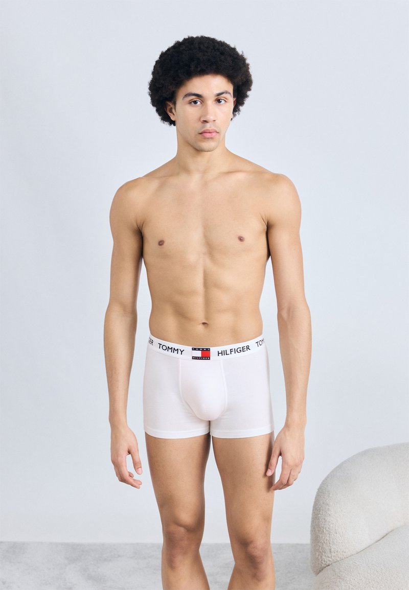 Λευκά ανδρικά εσώρουχα boxer με λογότυπο στη μέση σε μαύρο, κόκκινο και μπλε. Λείο βαμβακερό υλικό, εφαρμοστή σχεδίαση και κλασική σιλουέτα.