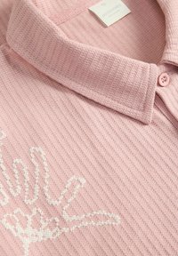 Roze geprofileerde poloshirt van ribstof, met een witte handafbeelding aan de voorkant en een button-down kraag.