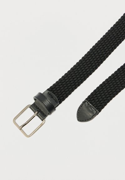Črni tkan pas z elastičnim, teksturiranim trakom. Ima srebrno kovinsko zaponko in črne usnjene poudarke na koncih.
