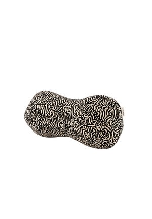 Cojín con patrón abstracto de laberinto en blanco y negro, con forma de maní y una pequeña etiqueta de tela en un lado.