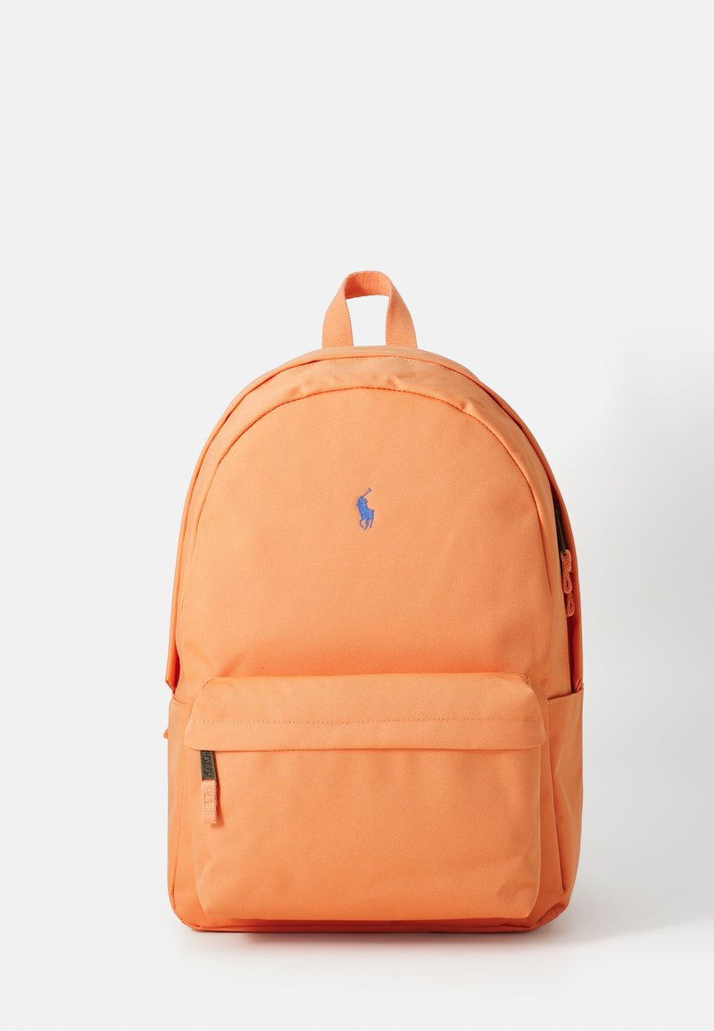 Zaino arancione con una texture di tessuto liscia, forma arrotondata, tasca frontale con zip e un piccolo logo ricamato in blu.