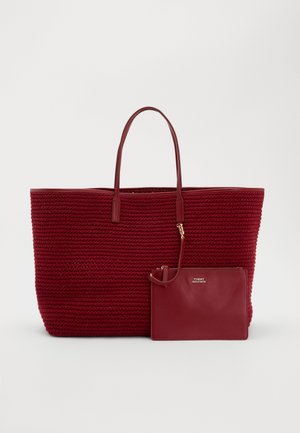 Sac fourre-tout rouge tissé avec deux poignées et pochette en cuir lisse attachée avec fermeture éclair et logo Tommy Hilfiger.