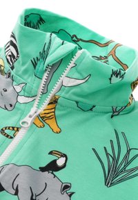 Ljusgrön zip-up jacka med olika djurtryck, inklusive tiger och noshörning, med en mjuk textur och en hög krage.