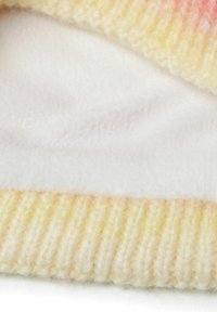 Coperta lavorata a maglia con una sfumatura che va dal giallo al rosa, caratterizzata da un lato inferiore morbido e soffice di colore bianco e un bordo a costine per aggiungere texture e calore.