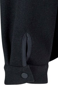 Zwarte stoffen manchette met een knoopsluiting en een kleine opening voor aanpassing. Het materiaal lijkt zacht met een gestructureerd oppervlak.