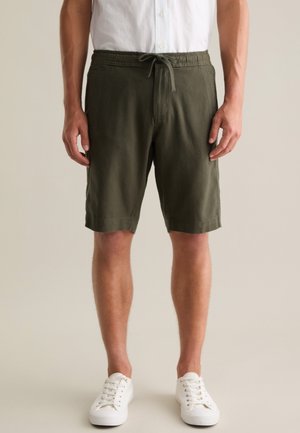 Pantaloni shorts verde oliva, fino al ginocchio, con vita elastica e cordino. Realizzati in un materiale leggero, presentano tasche laterali.