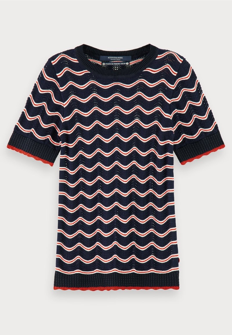 Haut en maille bleu marine à manches courtes avec des rayures horizontales ondulées blanches et rouges, et des bords rouges festonnés aux manches et à l'ourlet.