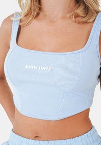 Top corto a coste di colore blu chiaro con scollatura quadrata e logo ricamato "SIXTH JUNE" al centro. Tessuto morbido con design aderente.