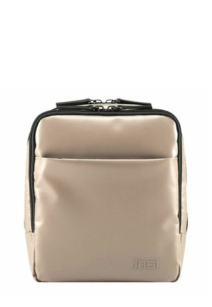 Zaino in nylon beige con zip nere, forma rettangolare, tasca frontale e dettagli del logo in rilievo. Texture liscia con un design minimalista.