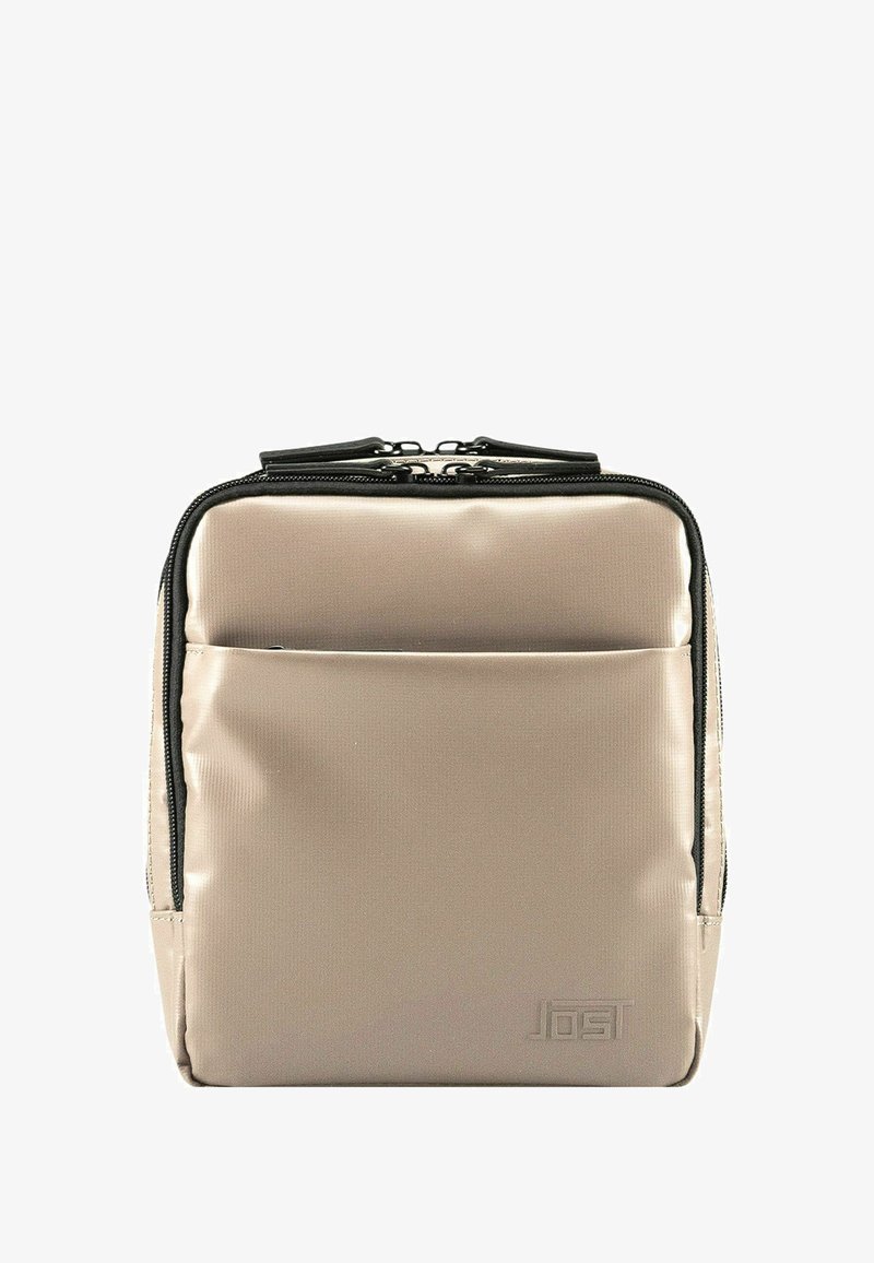 Zaino in nylon beige con zip nere, forma rettangolare, tasca frontale e dettagli del logo in rilievo. Texture liscia con un design minimalista.