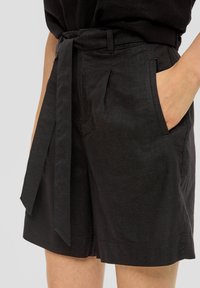 Shorts en lin noir avec une ceinture nouée, poches latérales, plis et une coupe décontractée avec un ourlet droit.