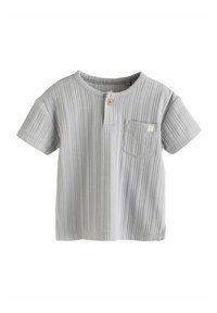 Chemise à manches courtes gris clair avec texture côtelée, présente un col à boutons, une poche poitrine unique et une petite étiquette sur la poche.