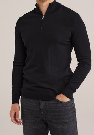 Zwarte pullover trui met een half-rits kraag, gemaakt van zacht breiwerk. Voorzien van lange mouwen en geribde manchetten en zoom.