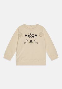 Sudadera beige con mangas largas, que presenta un diseño de cara de animal juguetona en negro y dorado. Tejido suave con bordes redondeados.